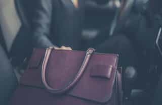 Woman driver reaching into purse